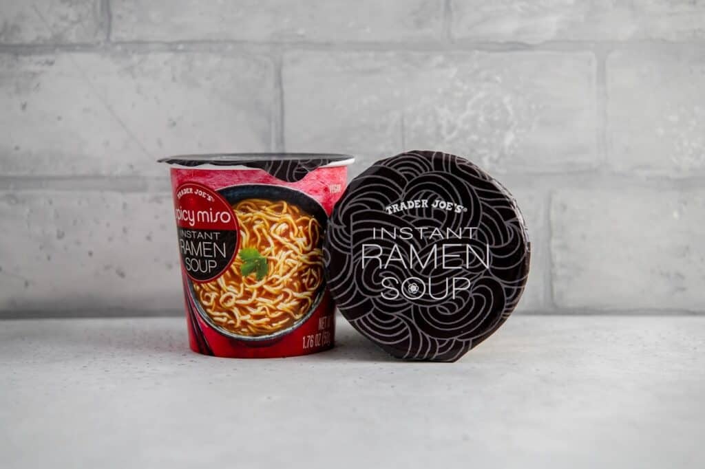 Vegan Trader Joe's product - instant miso ramen soup in front of gray brick backdrop.