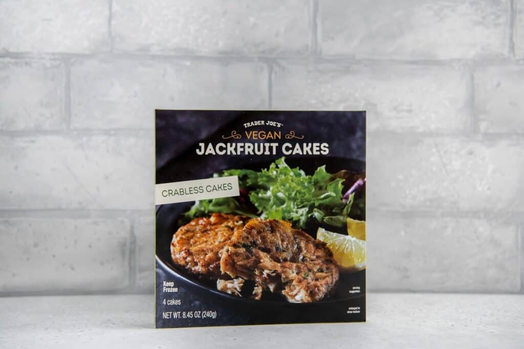 Vegan Trader Joe's product - jackfruit cakes in front of gray brick backdrop.