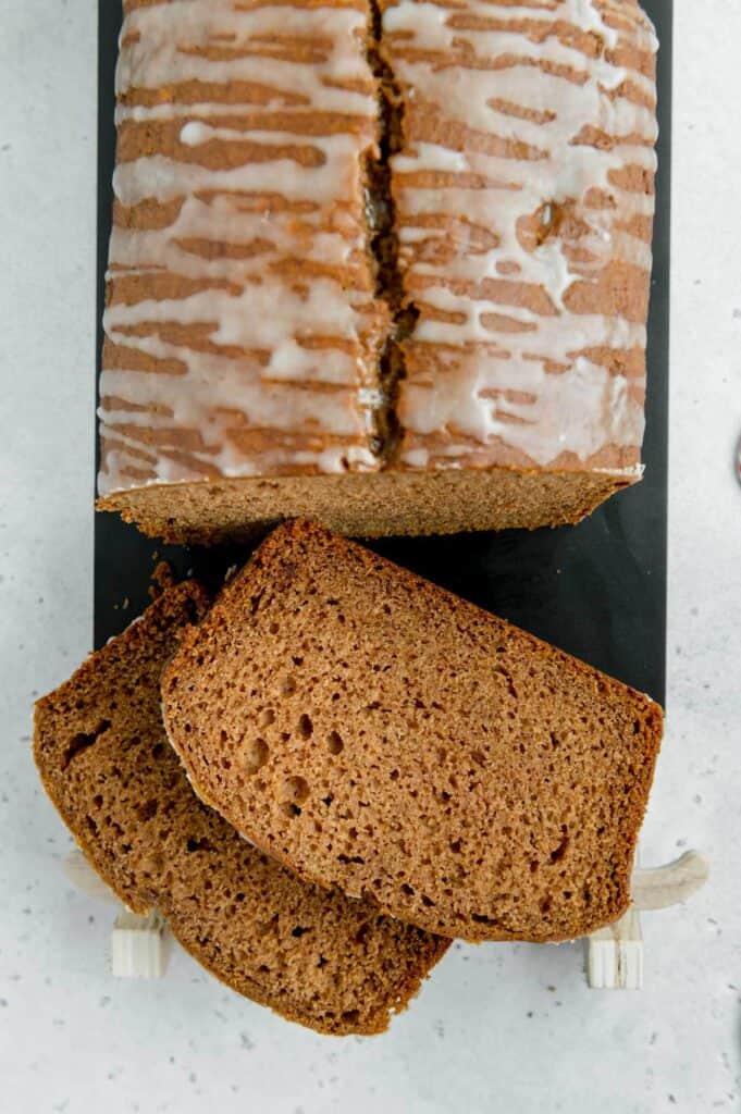 Overhead up-close photo of a gingerbread loaf with two slices cut out.