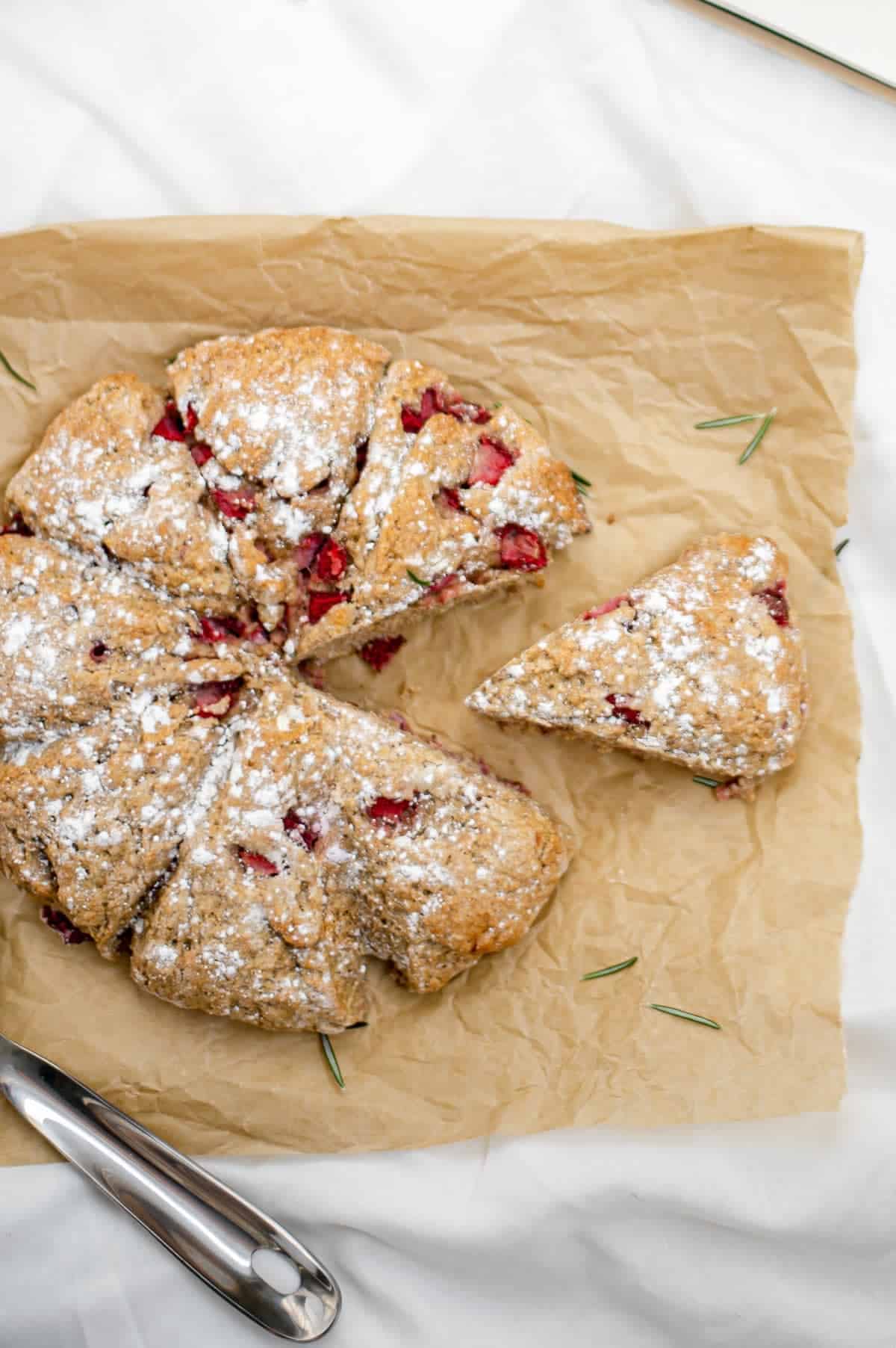 Overhead shot of vegan strawberry rosemary scones with a slice cut out.