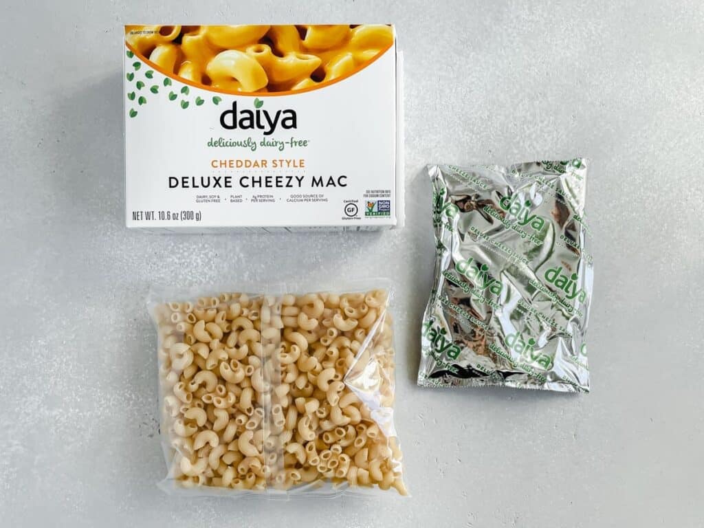 A box of Daiya deluxe cheesy mac, elbow macaroni in a bag and cheese sauce.