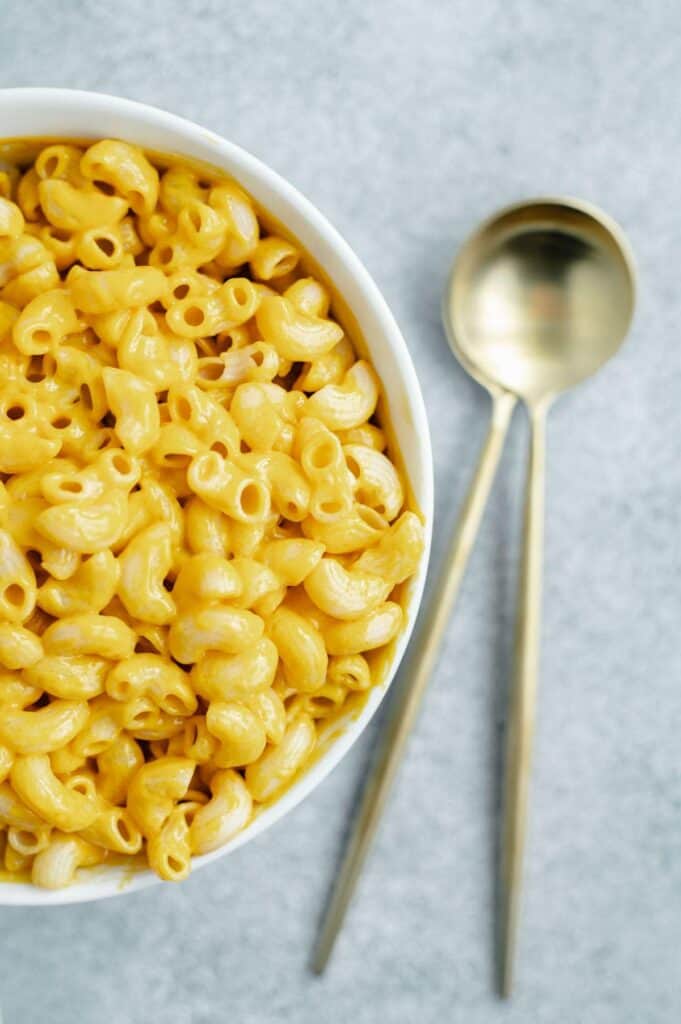 Upclose of a bowl of Daiya mac and cheese with two spoons on the side.