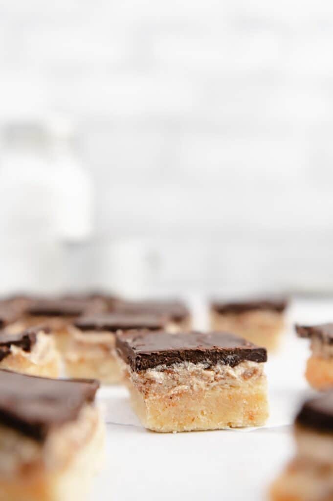 Upclose of a vegan millionaire shortbread cookie with several others scattered around.