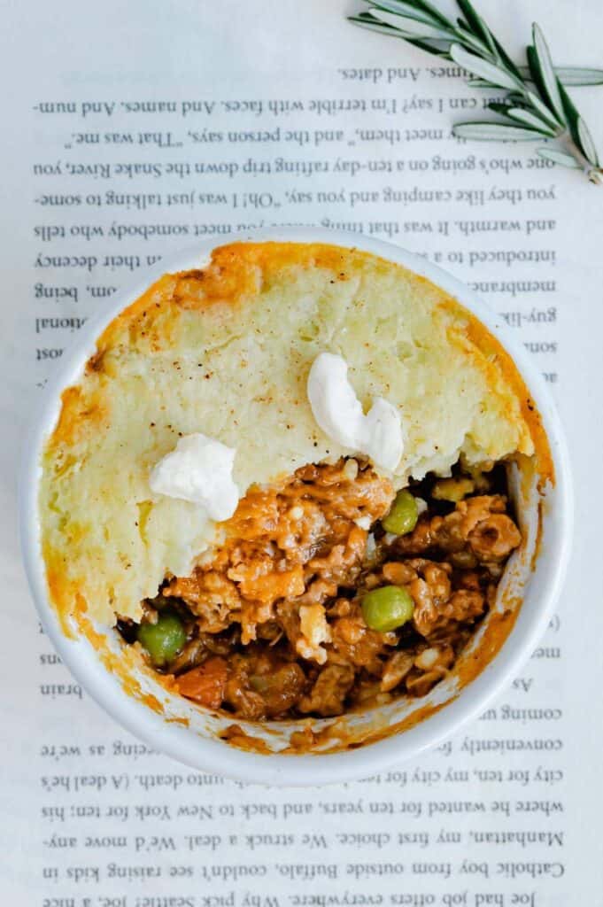 Overhead of a half eaten shepherd's pie on top of a page of a book.