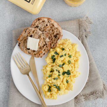 Flatlay of Just Eggs bottle, orange juice and a plate of Just Eggs with an English muffin.