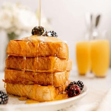 Maple syrup being poured on top of a stack of vegan French toast with Just Egg.