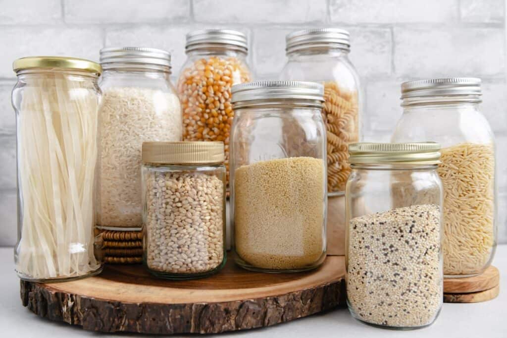 Different grains (pasta, popcorn, couscous, etc.) in mason jars.