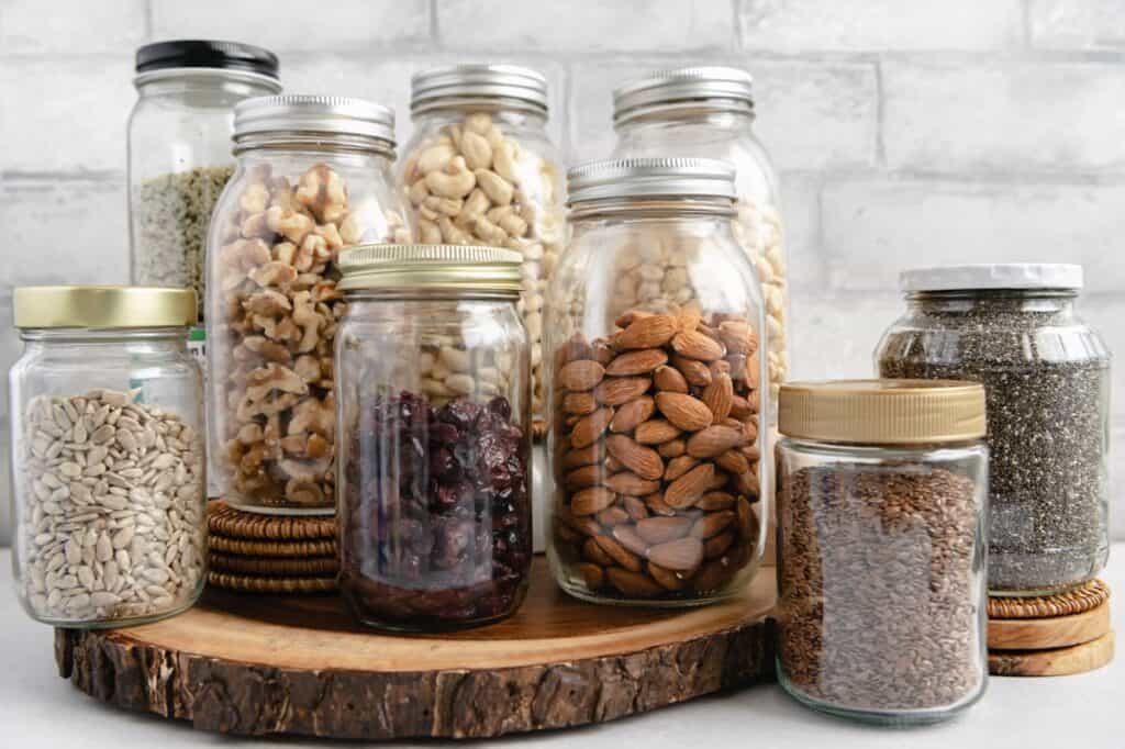 Different nuts and seeds (almonds, cashews, flaxseeds, chia seeds, etc.) in mason jars.