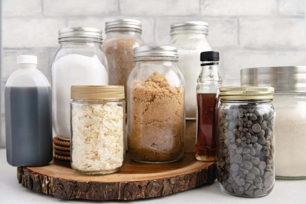 Different baking supplies (flour, sugar, chocolate chips, etc.) in mason jars.