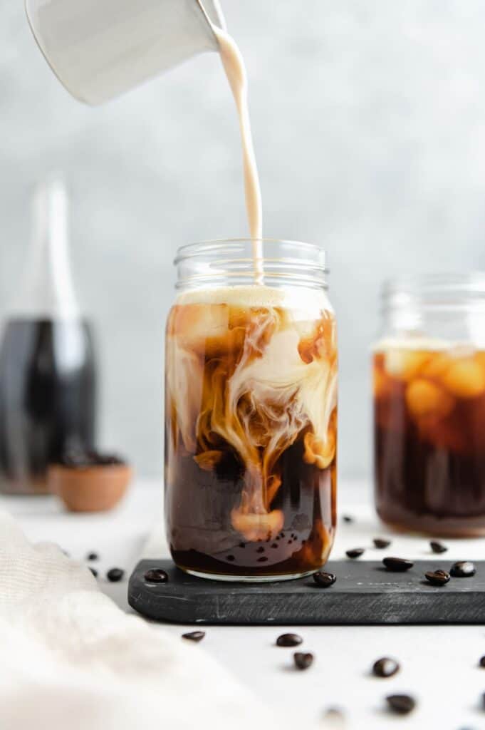 Iced coffee in jar, mug glass cup on the white table Stock Photo