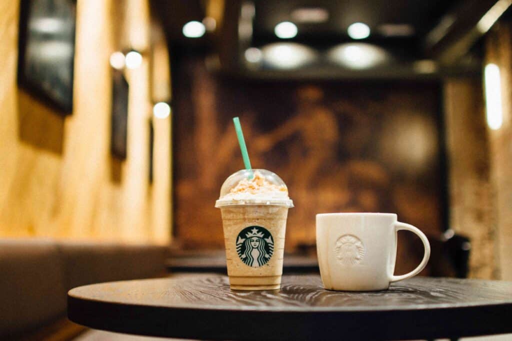 Starbucks Frappuccino and a coffee mug on a table.