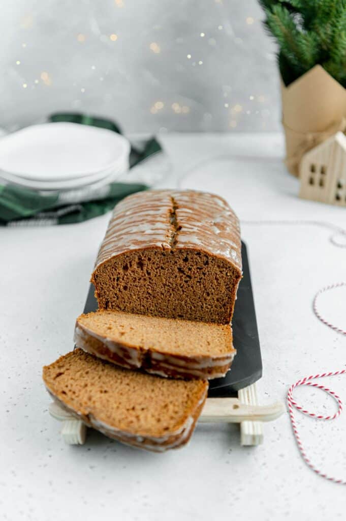 Vegan gingerbread loaf with seasonal Christmas elements in the scene.