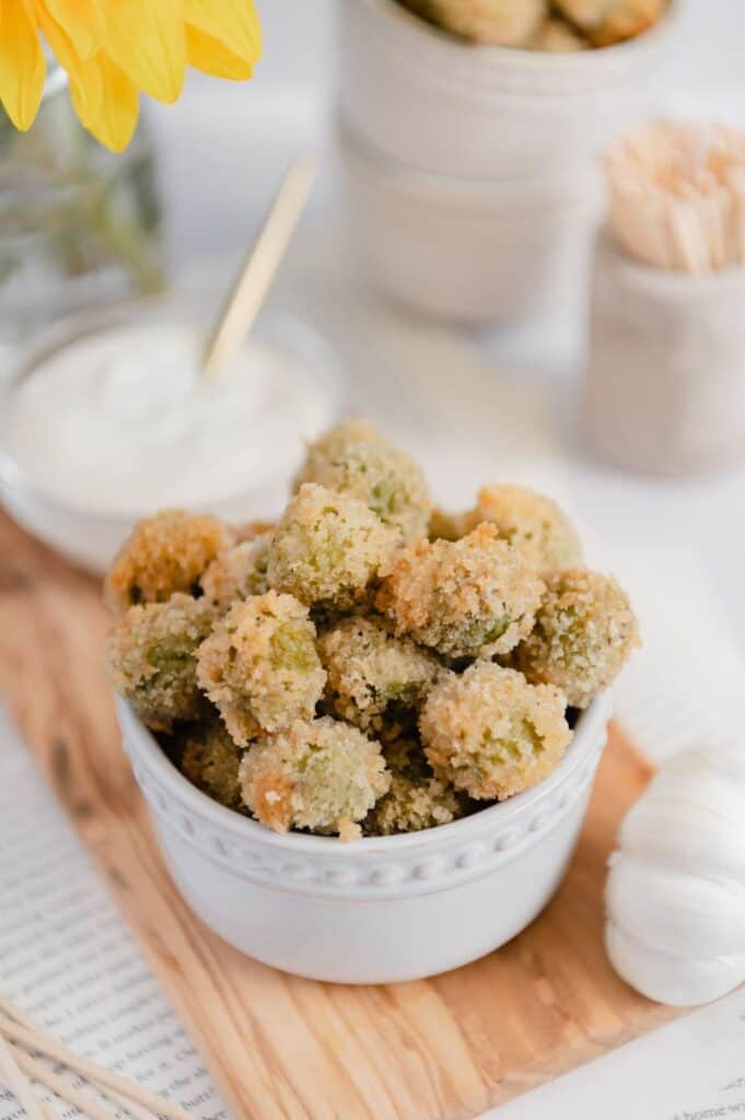 Upclose of crispy fried olives with vegan garlic aioli dipping sauce.