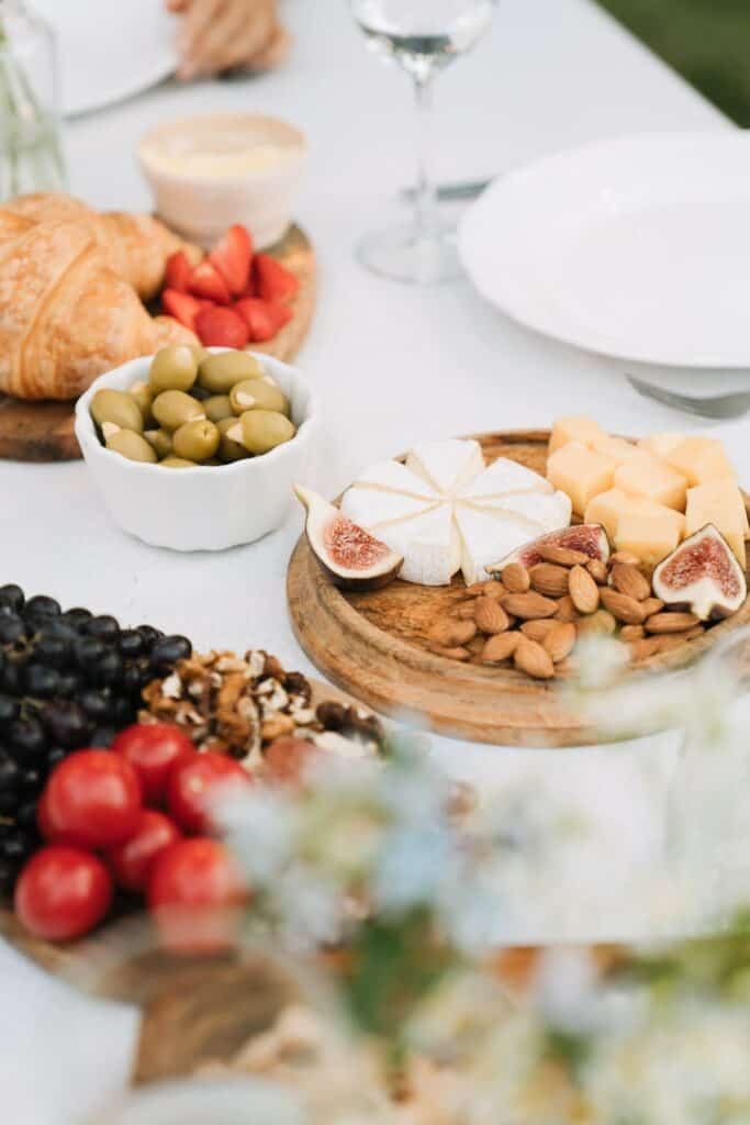 Vegetarian cheese board spread with nuts, cheese, olives, bread, and no meat.