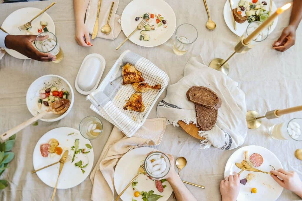 Overhead of a dinner table with friends enjoying a meal together.