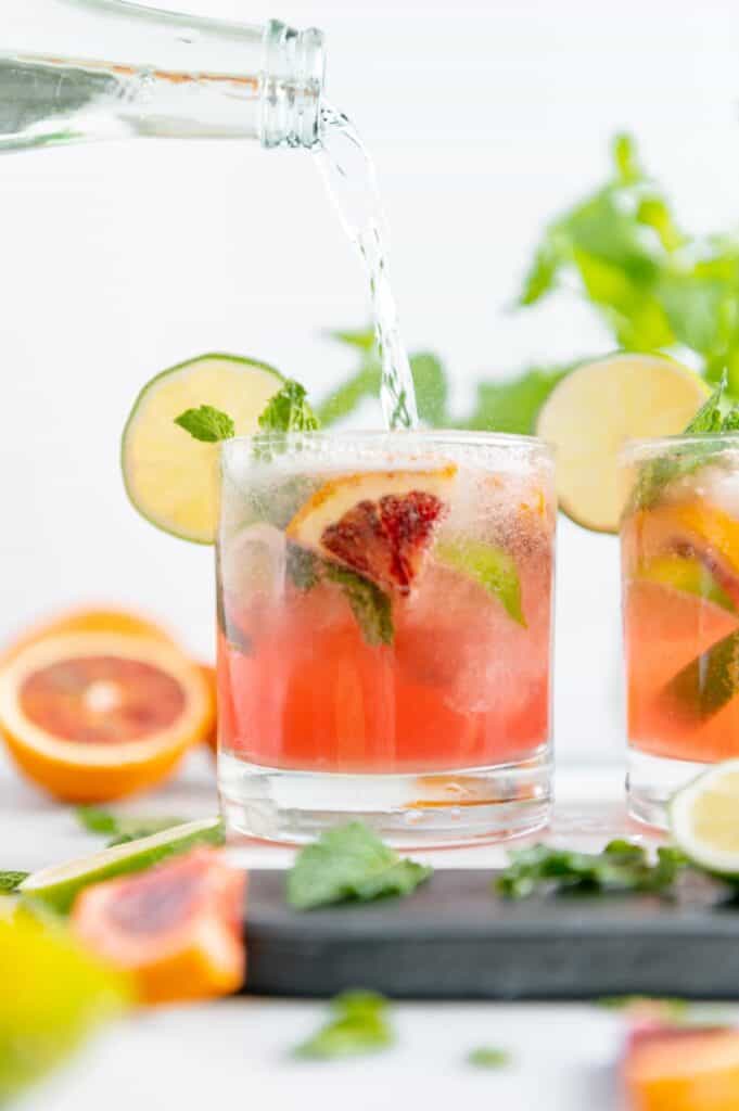 Soda water being poured to top off a mojito.