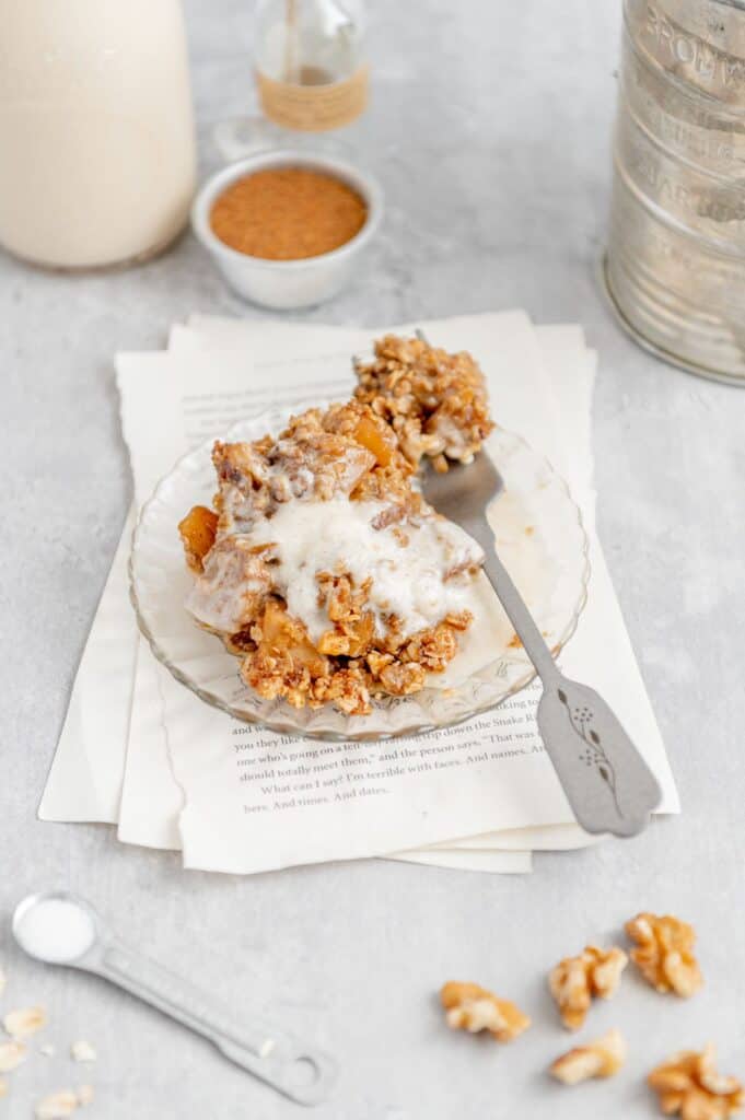 A plate of a sugar free apple crisp and a fork with a bite ready.