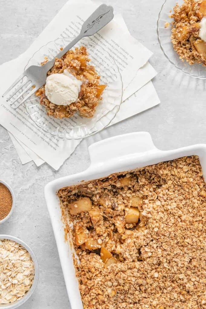 A plate of a sugar free apple crisp with vanilla ice cream on top.