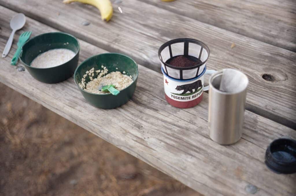 Oatmeal and coffee on a camping table.