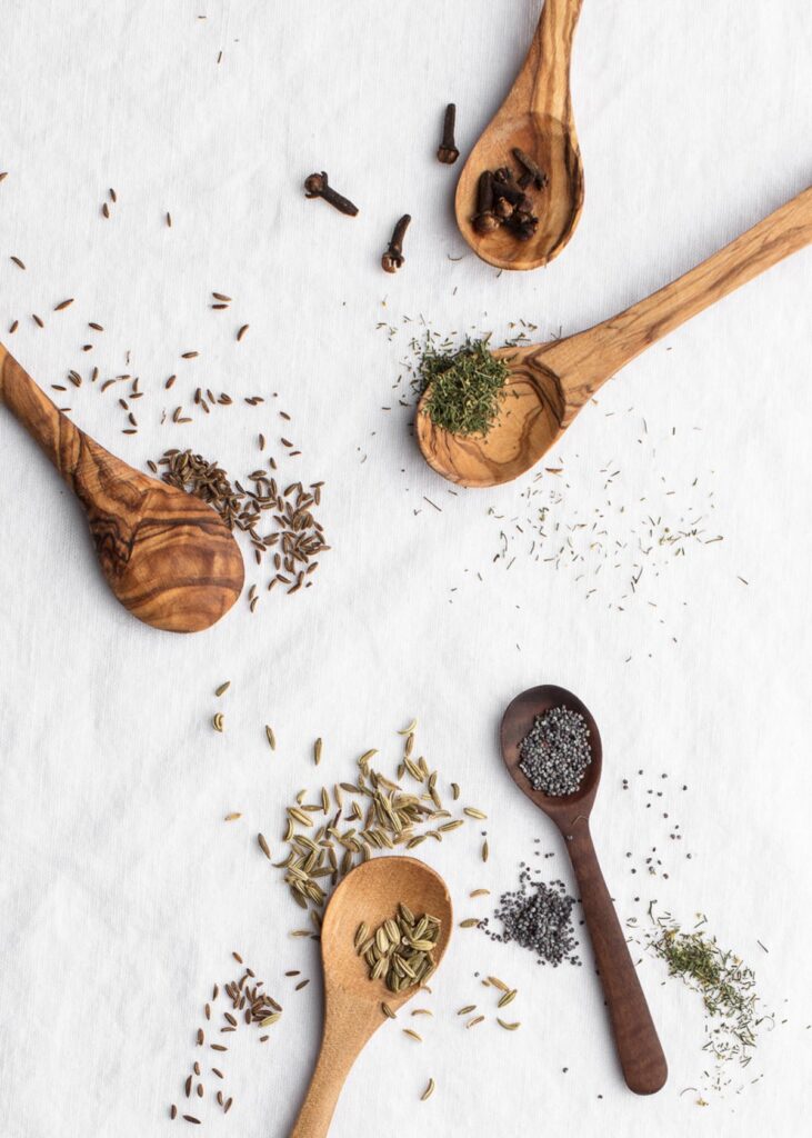 Different seeds and spices on spoons.