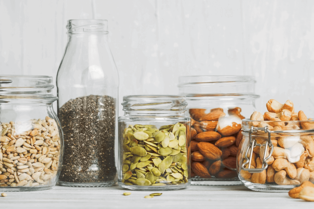 Nuts and seeds in different glass jars.