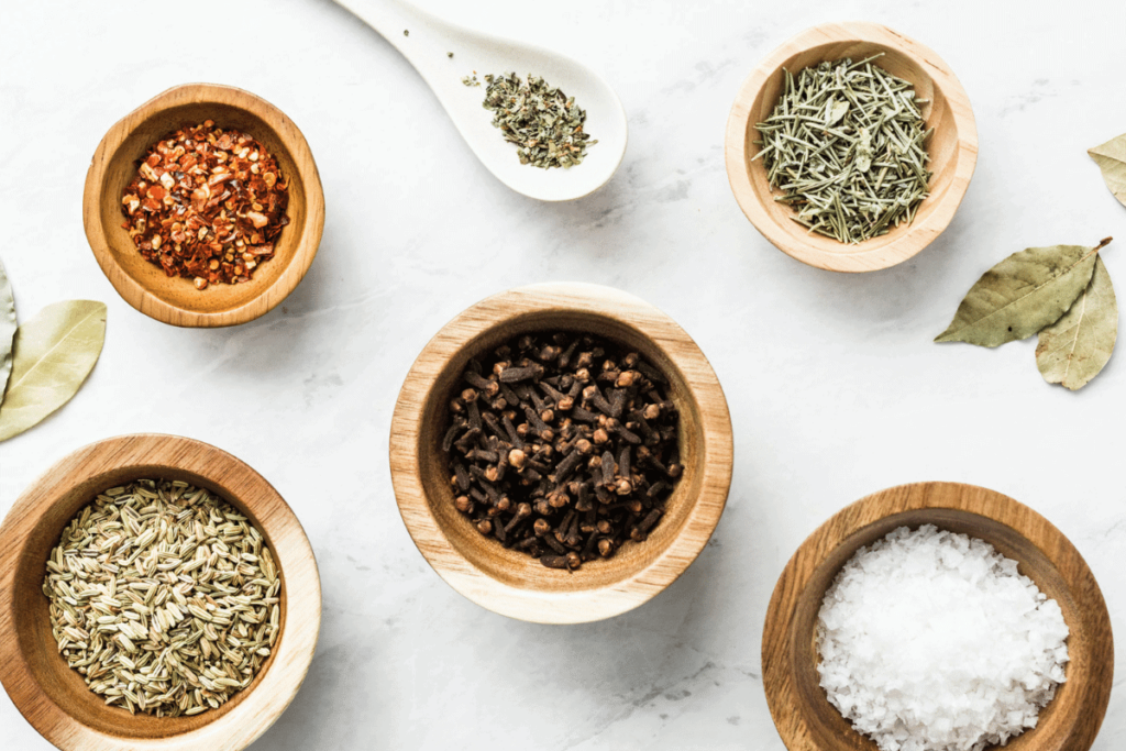 Several herbs and spices in wood bowls.