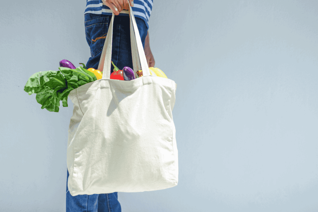 A reusable grocery bag full of fresh produce.