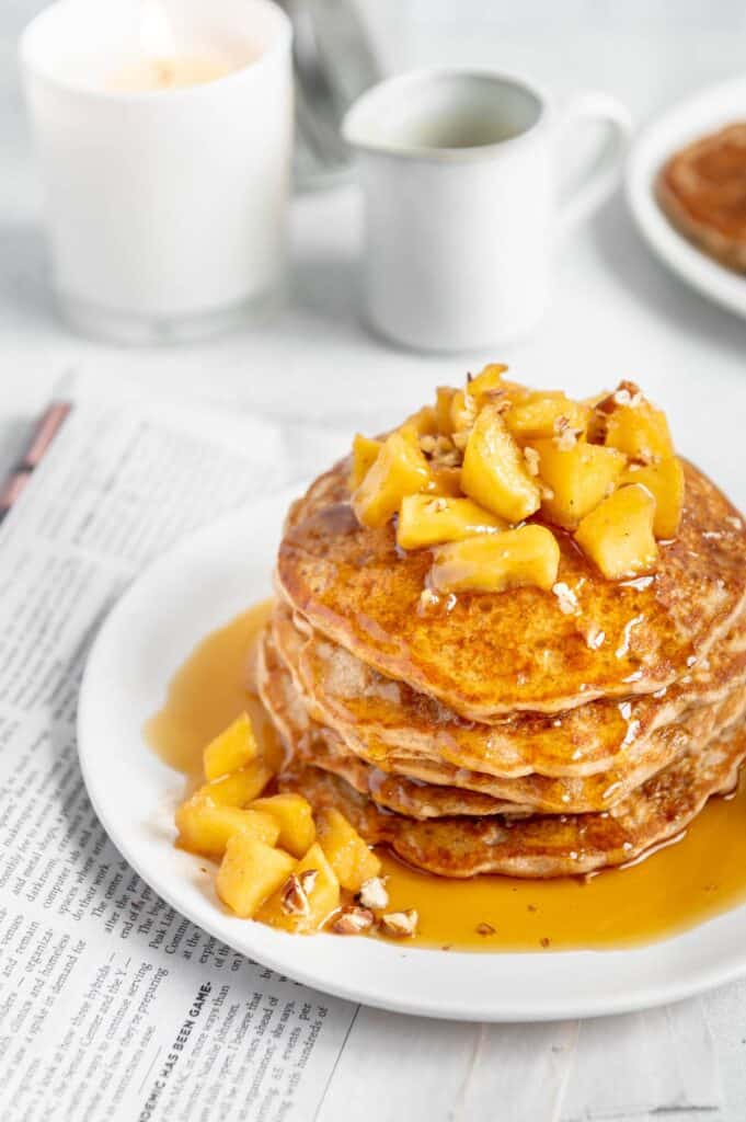 A stack of pancakes drenched in maple syrup.