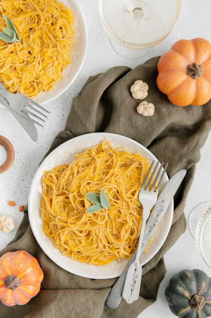 Vegan pumpkin pasta with a fork and knife ready to be eaten.