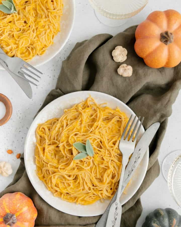 Vegan pumpkin pasta with a fork and knife ready to be eaten.