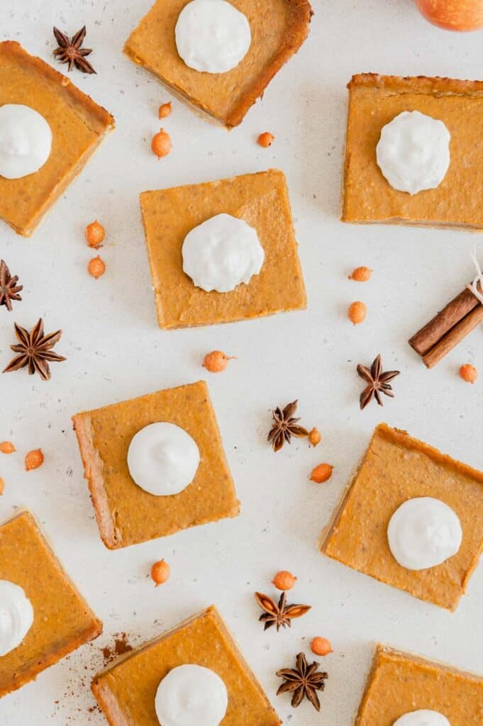 Pumpkin bars scattered with cinnamon sticks and star anise.