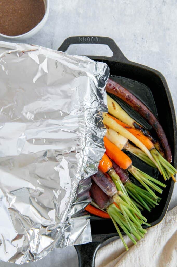 Aluminum foil being put over the rainbow carrots.