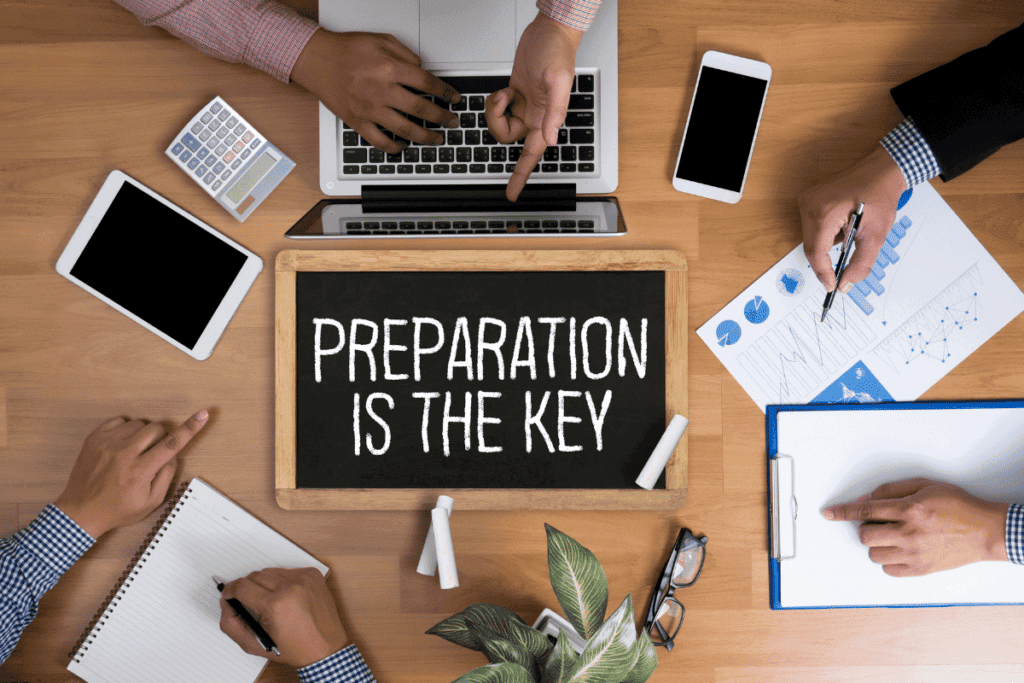 Overhead of an office table with a sign that reads "preparation is the key."
