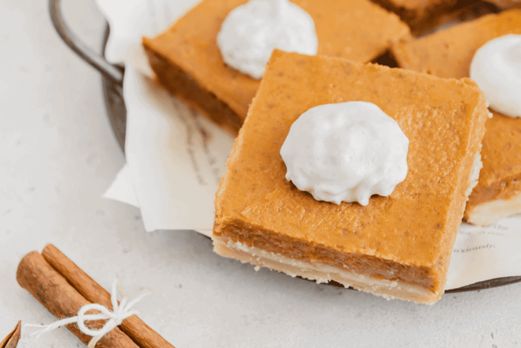 Homemade vegan pumpkin pie bars with whipped cream.