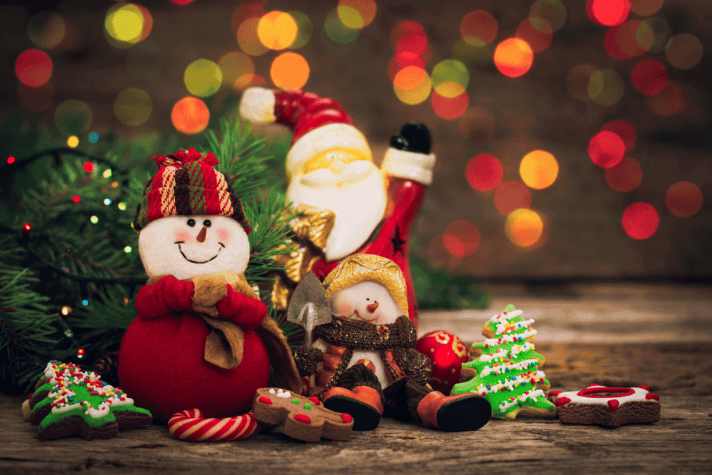 A stuffed snowman and Santa Claus with glowing Christmas lights in the background.