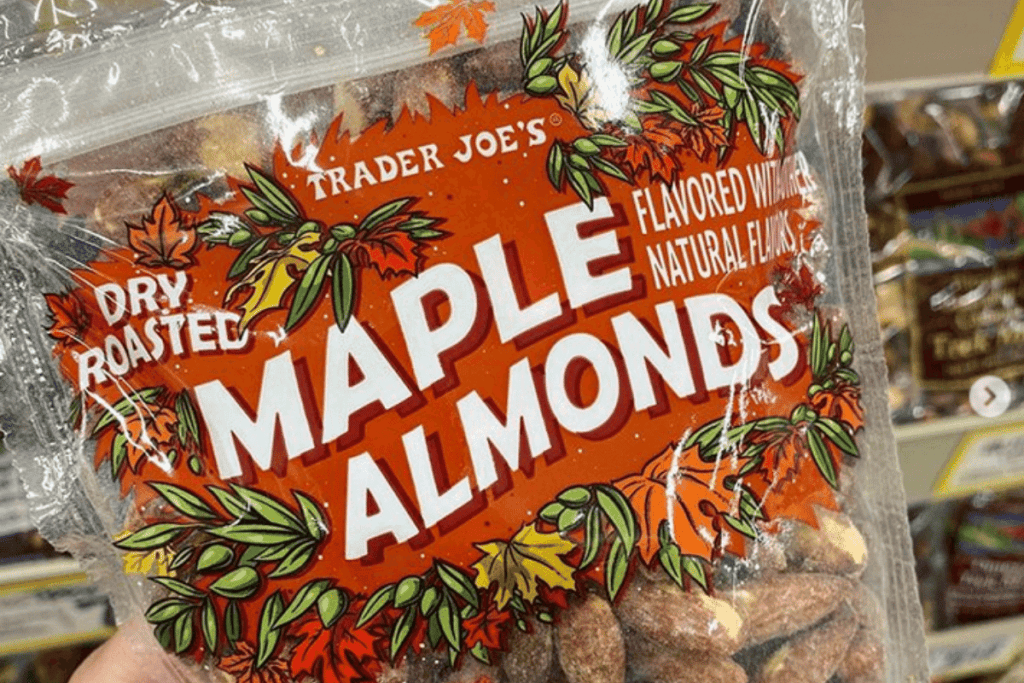 A hand holding up a bag of Trader Joe's maple almonds.