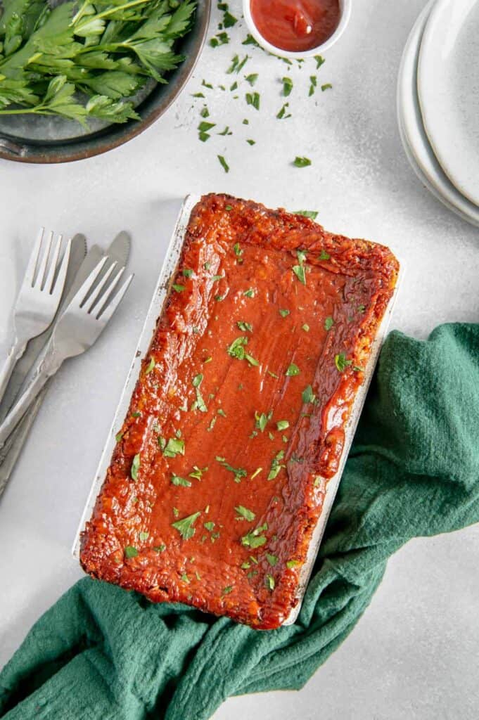 Overhead of a vegan meatloaf with a bright ketchup glaze.