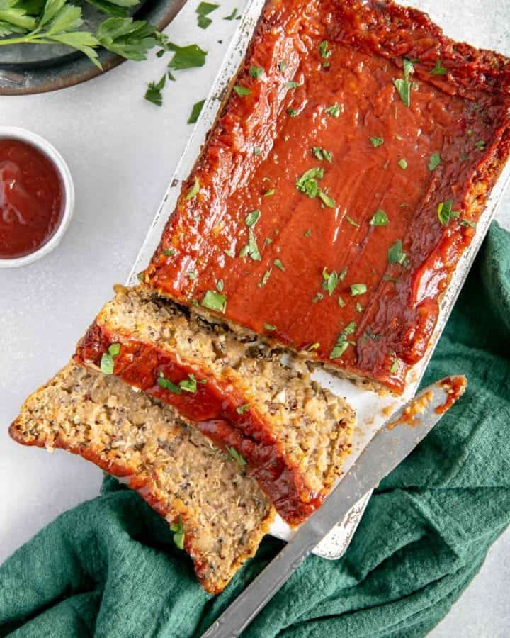 A couple of slices of meatloaf cut onto a cutting board.