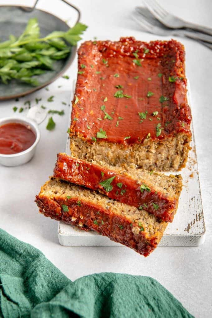 A lentil, quinoa, and mushroom meatloaf on a wood cutting board.