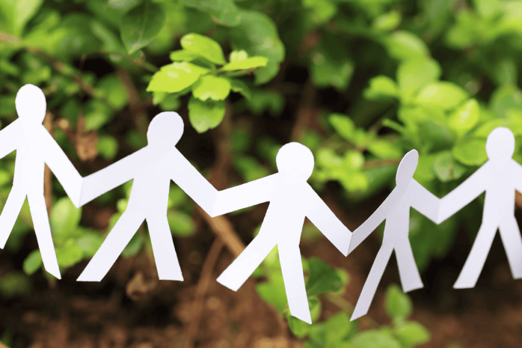 A paper cutout of people in front of a tree.