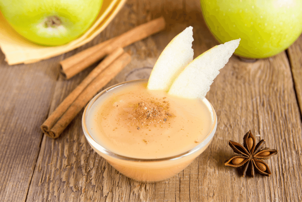 Applesauce surrounded by cinnamon and Granny Smith apples.