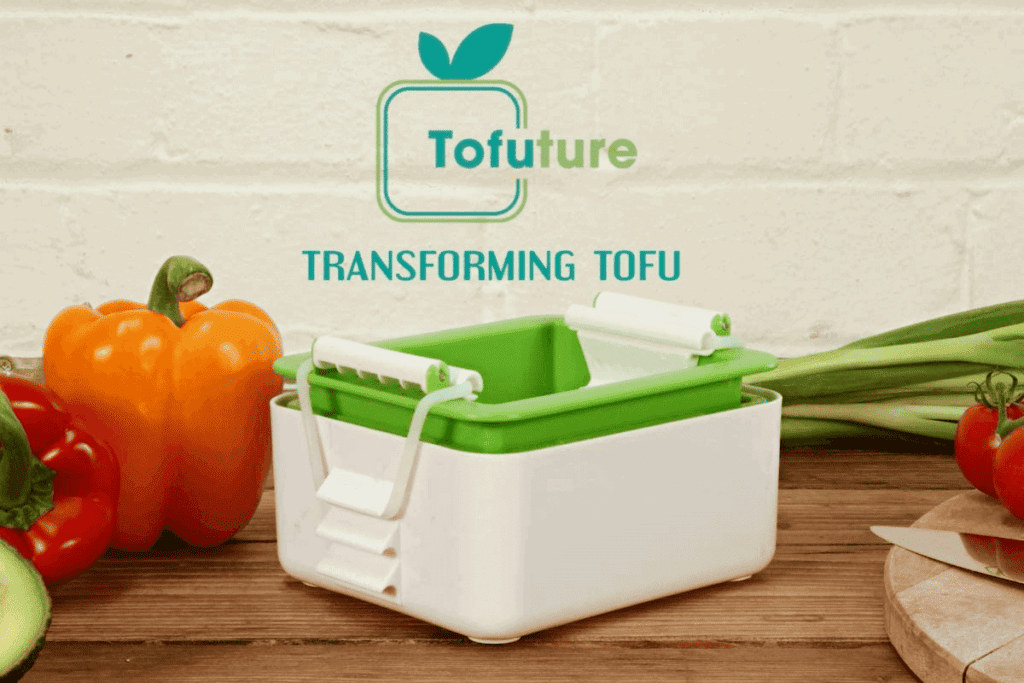 Tofuture tofu press on a butcher block countertop.