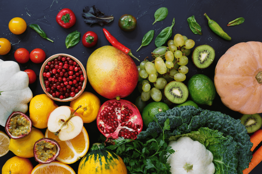 Fruits and greens spread out on a table.