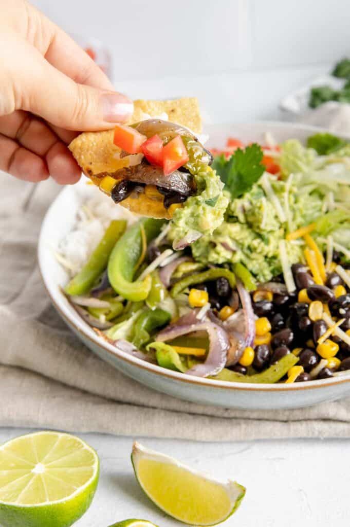 A chip scooping up everything in a burrito bowl.
