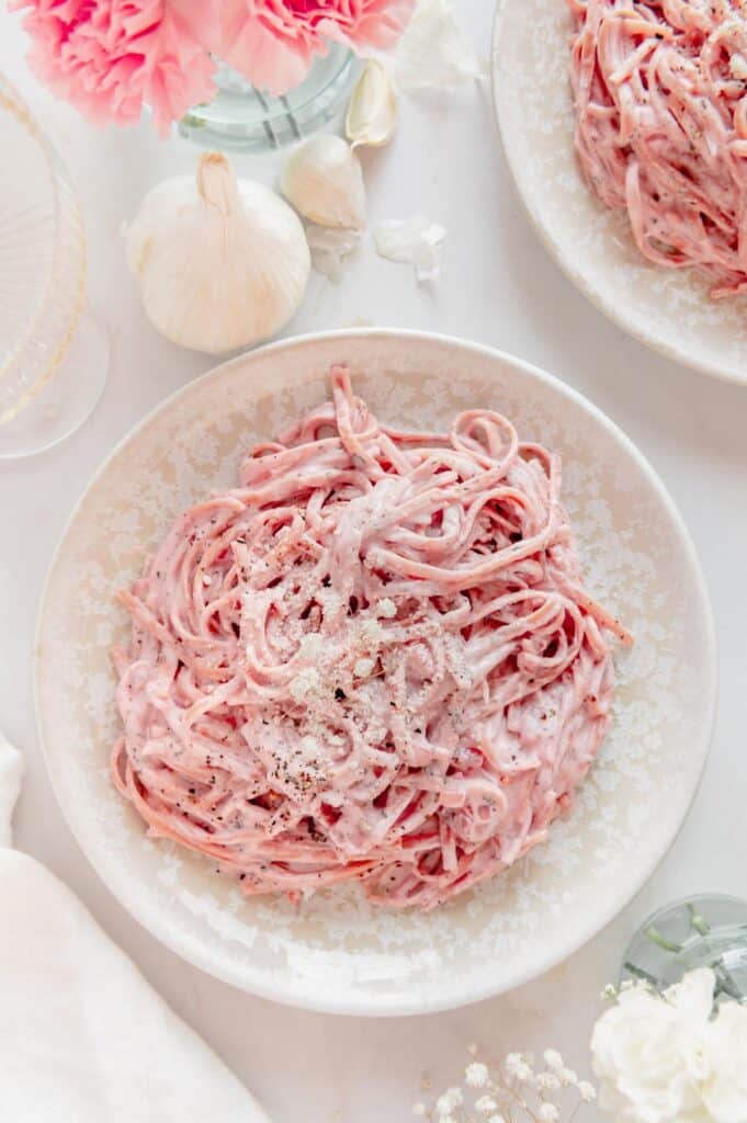 A plate of pink pasta with garlic.