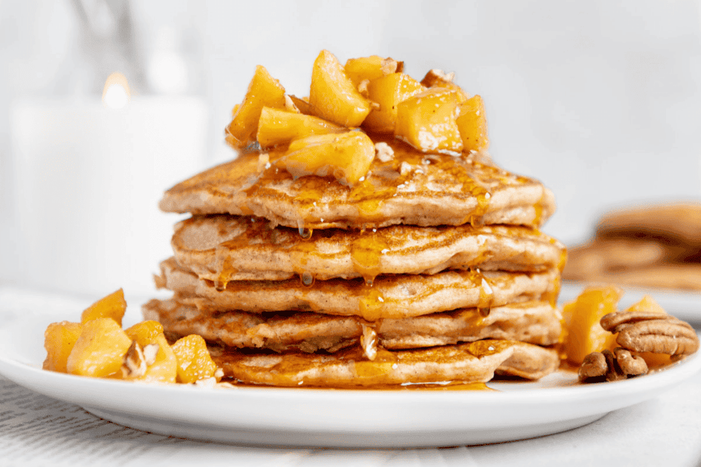 A stack of vegan pancakes with syrup dripping down them.