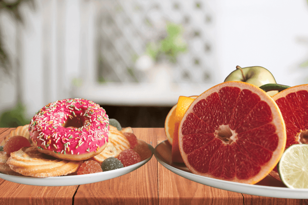 A plate of fruit next to a plate of donuts and cookies.