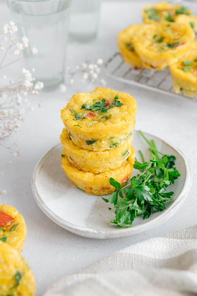 Three egg bites filled with veggies stacked on top of one another.