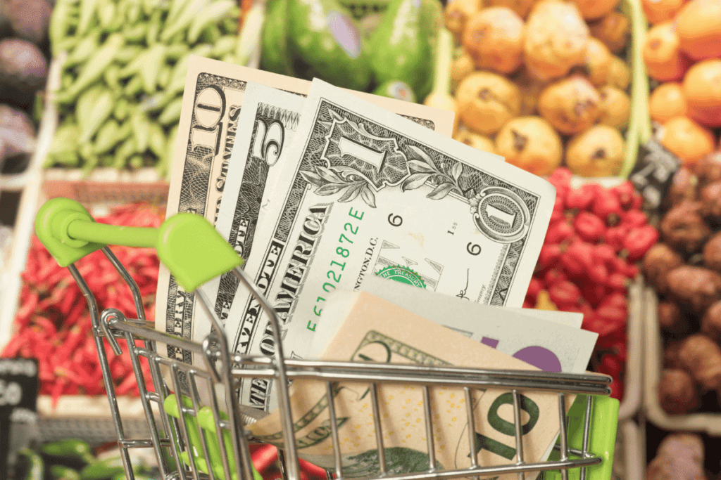 A grocery cart filled with dollar bills.