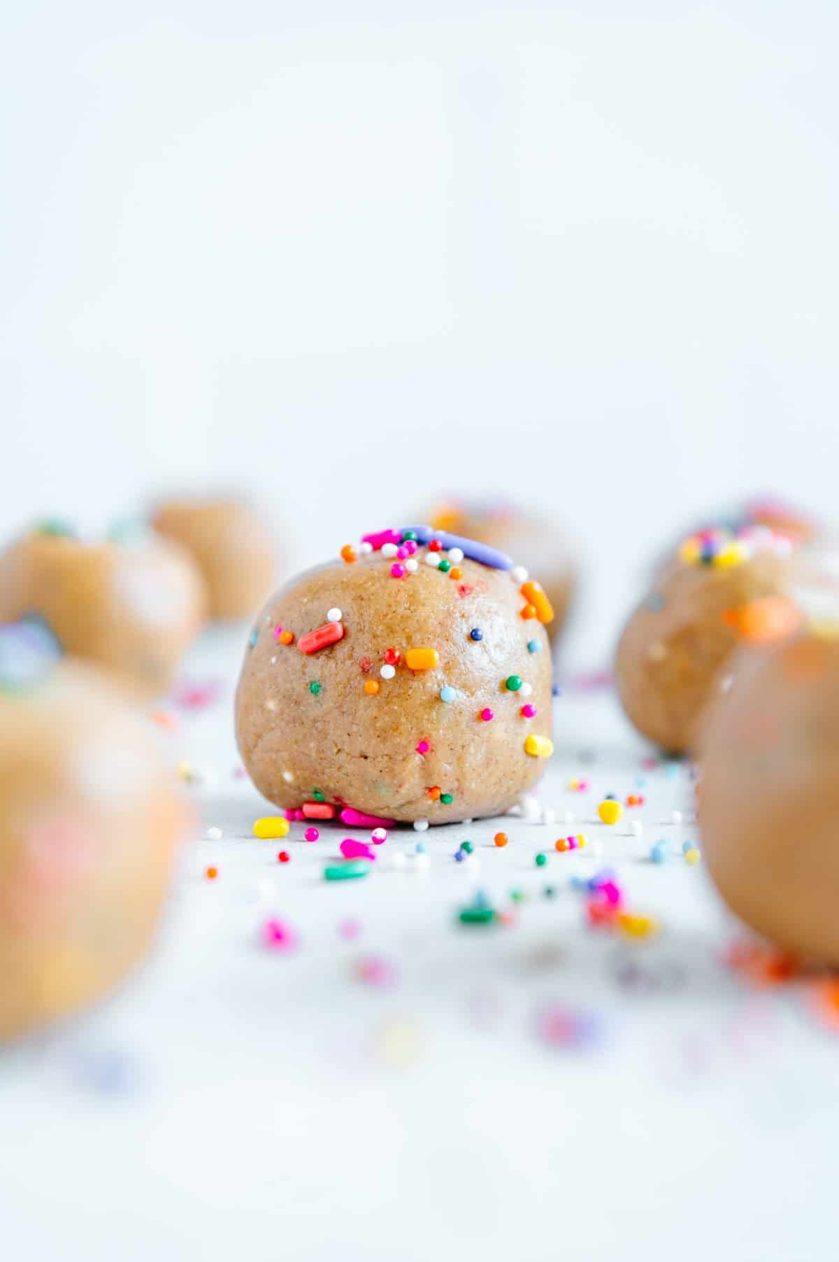 Upclose of a funfetti bite rolled in sprinkles.